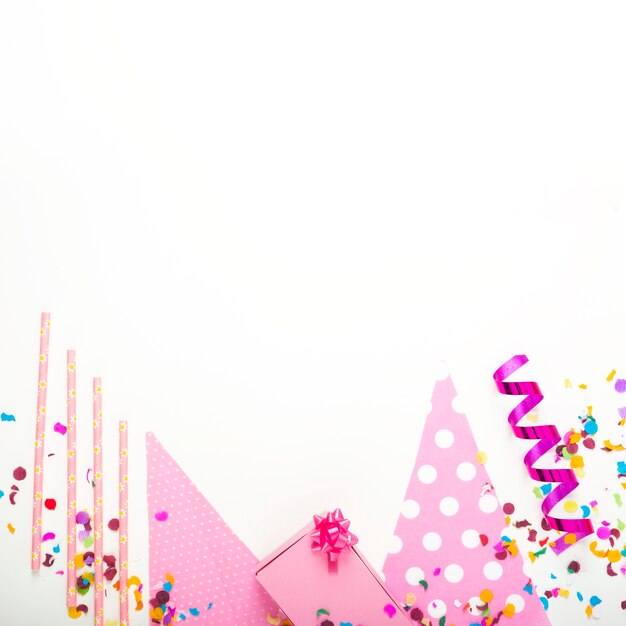 Present pink gift box with decorative items on white backdrop