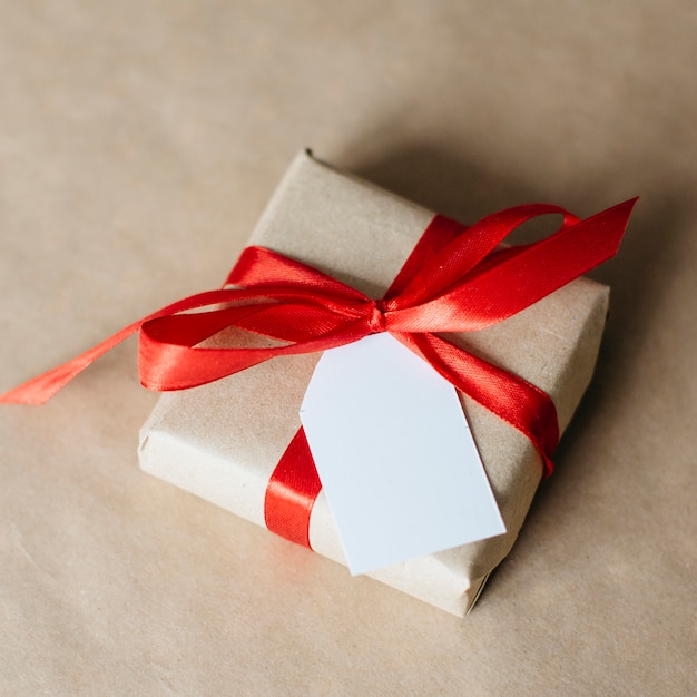 Present wrapped with red ribbon and postcard