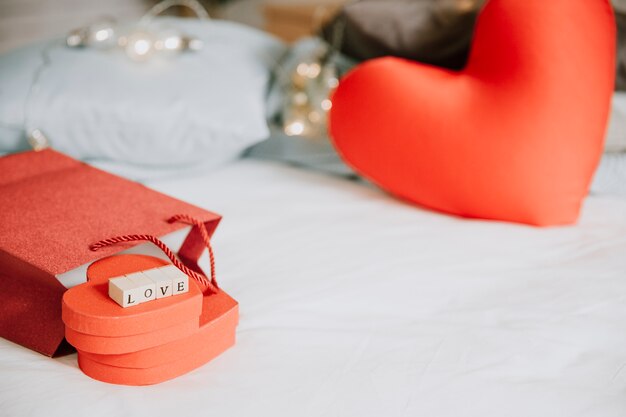 Presents and heart cushions on bed