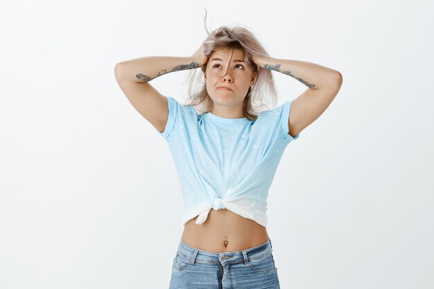 Pressured tired blonde girl posing in the studio