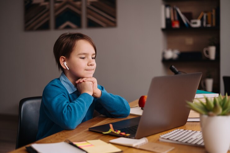 Free Photo a preteen boy uses a laptop to make online classes