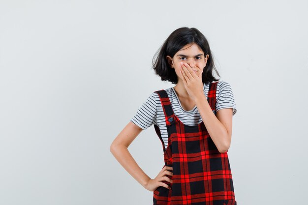 Preteen girl holding hand on her mouth in t-shirt