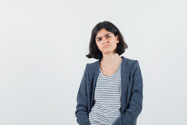 Preteen girl looking at camera in shirt,jacket and looking displeased , space for text