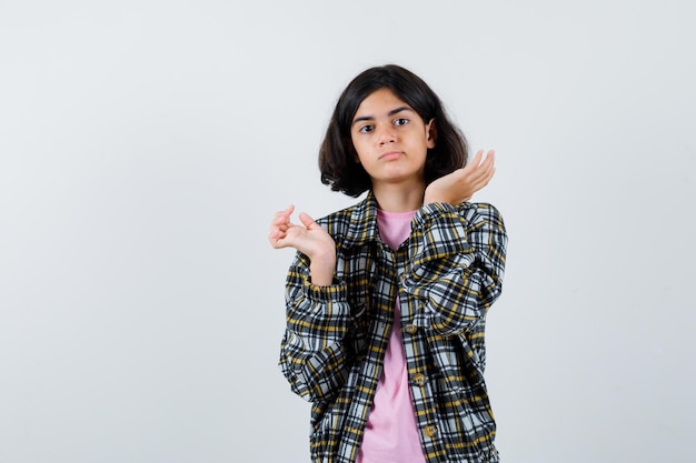 Preteen girl showing i don't know gesture in shirt,jacket front view.