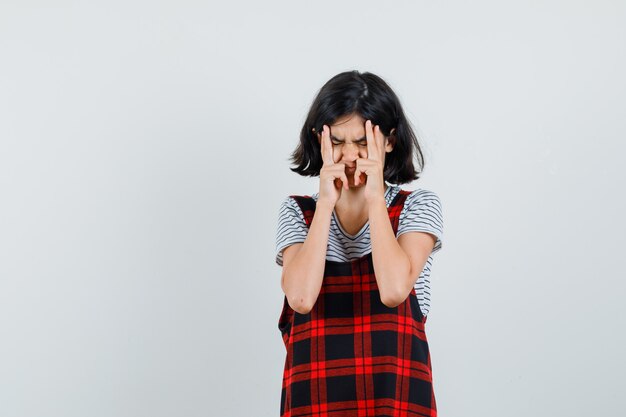 Preteen girl in t-shirt,jumpsuit squeezing her face and looking stressful