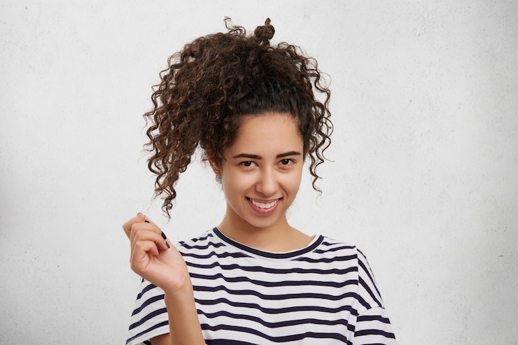Free Photo pretty adorable young female with curly pony tail has shy expression