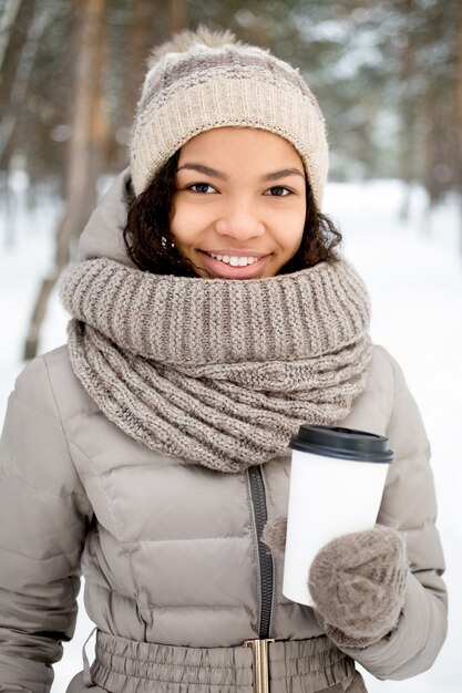 Pretty African woman drinking coffee outdoors