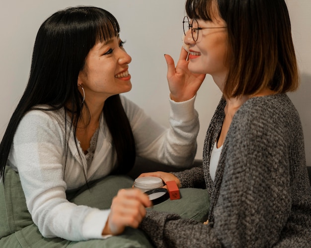 Foto gratuita ragazze abbastanza asiatiche che provano i prodotti di trucco