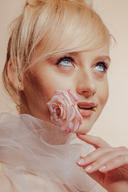 Ragazza abbastanza attraente con capelli biondi, riprese di moda, rosa, sfondo semplice