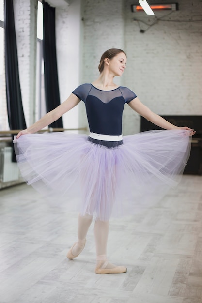 Free photo pretty ballerina dancing in studio