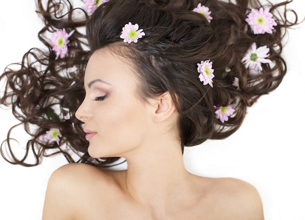 Free photo pretty beautiful girl lying with bright flowers in her hair bright makeup isolated on white