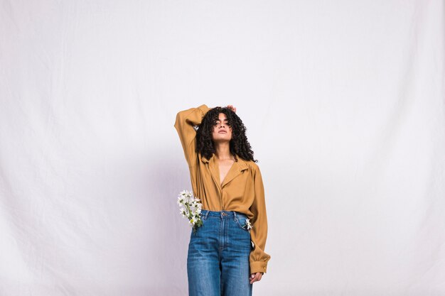 Pretty black woman with daisy flowers in jeans pocket