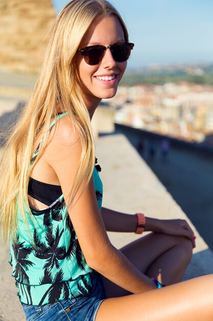 Pretty blonde girl sitting on the roof.