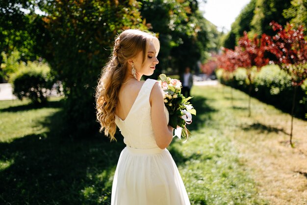 Pretty blonde girl with long hair in park.