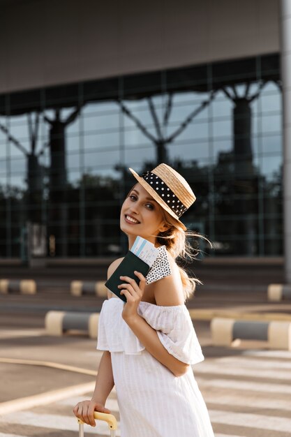 Pretty blonde woman in hat smiles sincerely