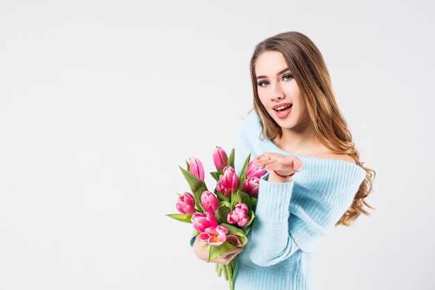 Pretty blonde woman holding bunch of tulips