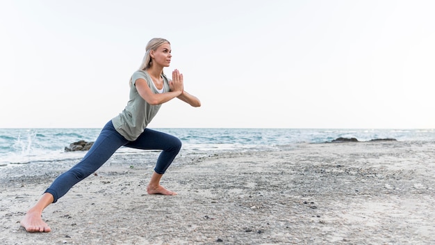 Довольно блондинка упражнениями йоги на открытом воздухе