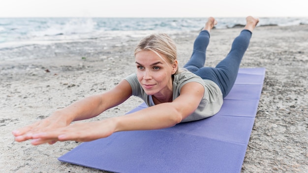 Pretty blonde woman practicing yoga outdoors