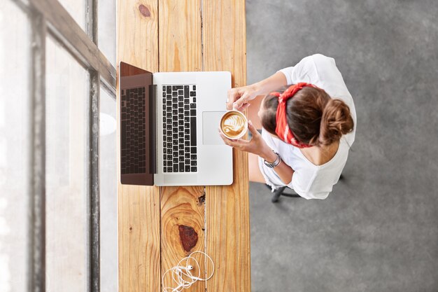 Pretty blonde woman sitting in cafe top view