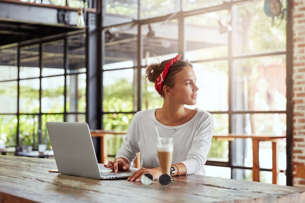 Free photo pretty blonde woman sitting in cafe