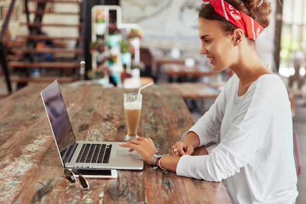 Free photo pretty blonde woman sitting in cafe