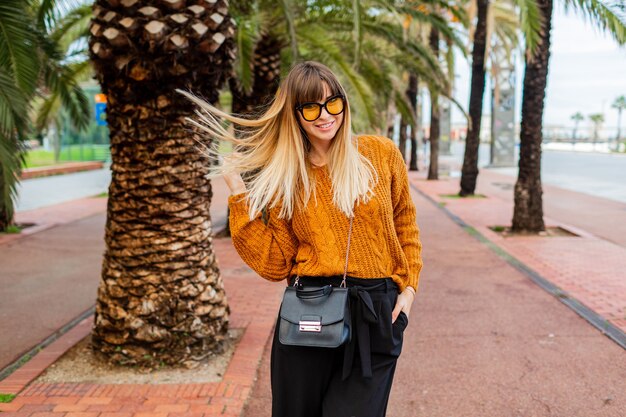 Pretty blonde woman traveling and enjoying autumn in Barcelona