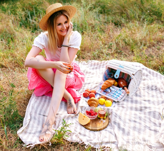 Free photo pretty blonde woman wearing vintage style outfi , enjoying countryside picnic