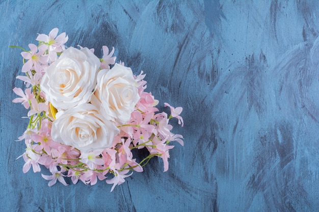 Pretty bouquet of white and pink flowers on blue.