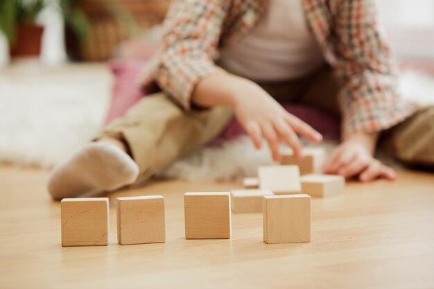 Bel ragazzo che gioca con i cubi di legno a casa