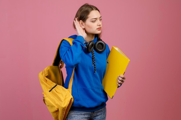 Pretty brunette girl standing touching ear listening