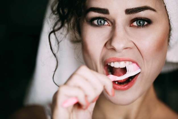 Free photo pretty brunette woman cleans her teeth