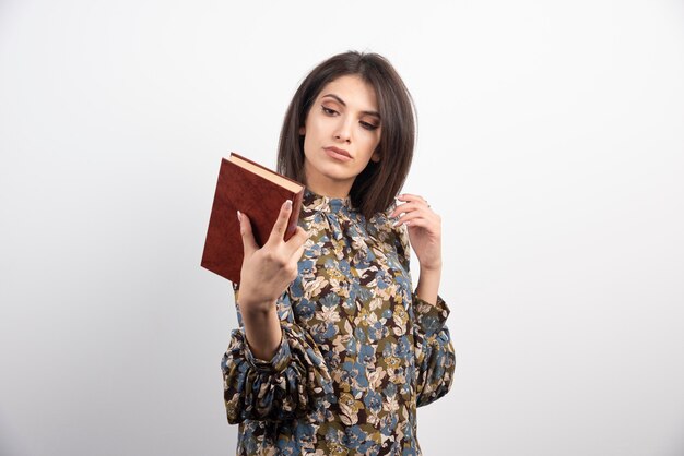 Pretty brunette woman looking at a book.