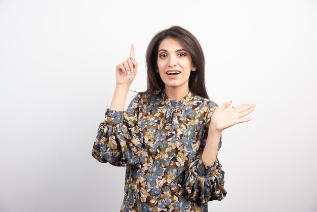 Pretty brunette woman standing on a white background. 