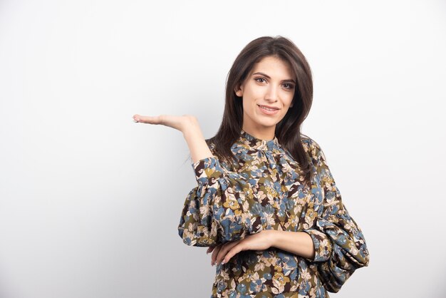 Pretty brunette woman standing on a white background. 