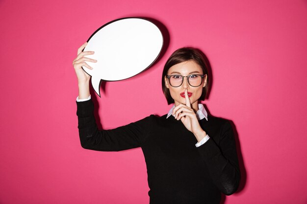 Pretty businesswoman holding speech bubble and showing speech bubble isolated