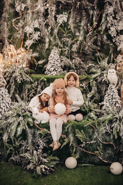 Pretty caucasian children pose for the camera in a beautiful christmas decoration and smile