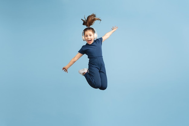 Free photo pretty caucasian girl portrait isolated on blue studio background with copyspace