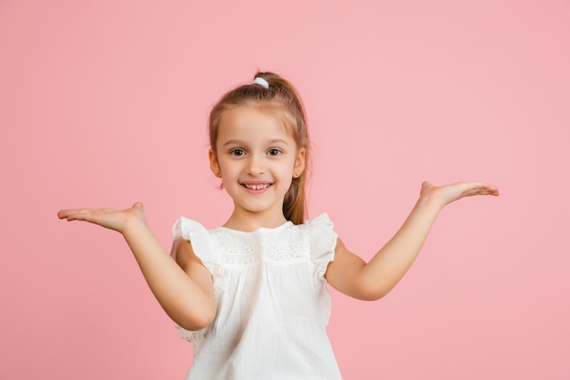 Pretty caucasian girl portrait isolated on pink studio background with copyspace