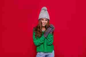 Free photo pretty charming young woman on red wall in winter outfit