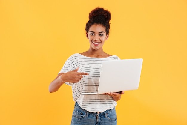 Pretty cheerful african lady and holding laptop isolated