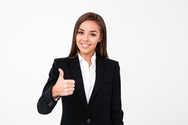 Pretty cheerful business woman showing thumbs up