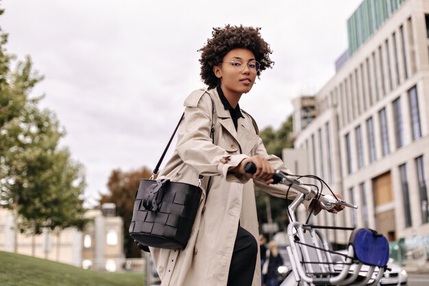 Pretty cheerful lady walks with bicycle