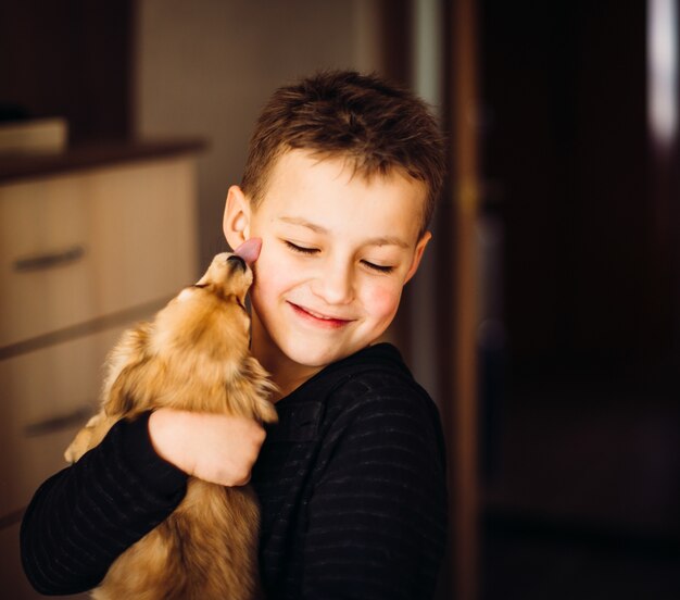 かわいい子は小さな犬を抱擁する