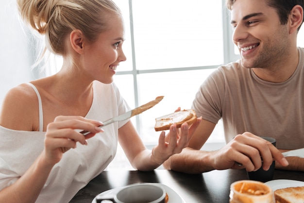 Pretty couple have breakfast in the kitchen