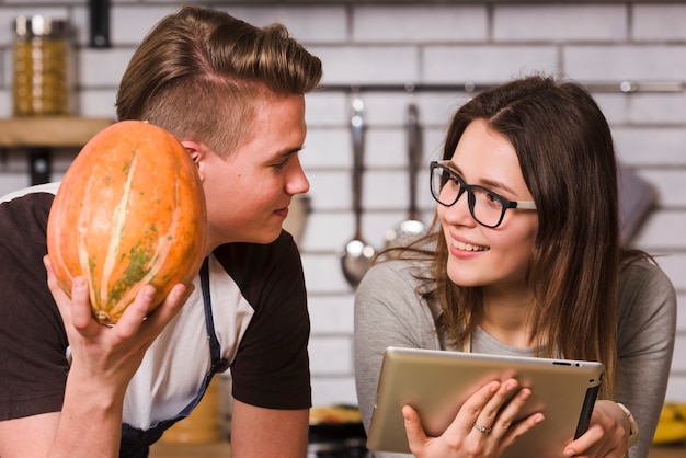 Free photo pretty couple using tablet in kitchen