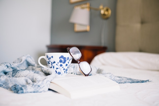 Pretty cup and glasses on opened book