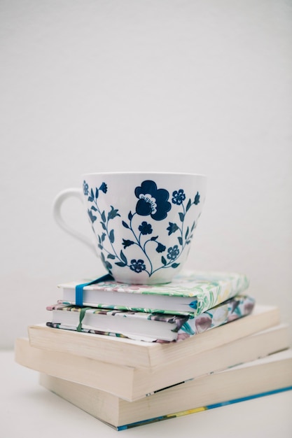 Pretty cup on pile of books