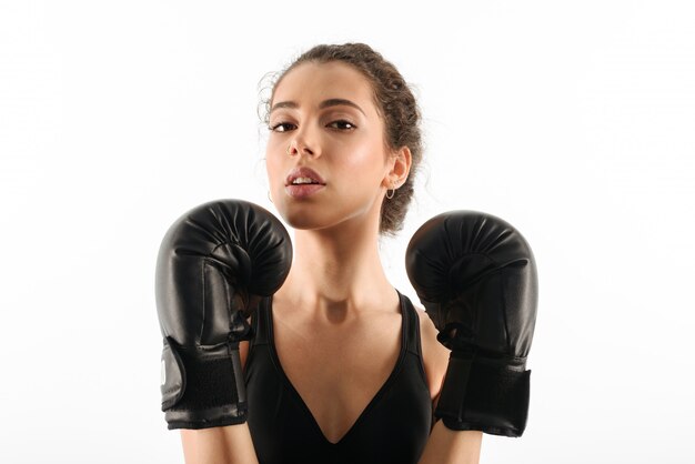 Pretty curly brunette fitness woman in boxing gloves