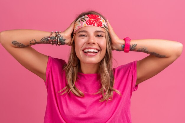 Pretty cute smiling woman in pink shirt boho hippie style accessories smiling emotional fun posing on pink isolated