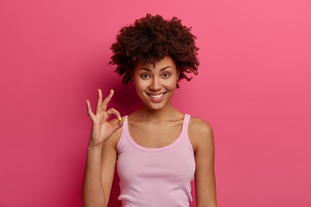 Pretty dark skinned female model shows okay gesture